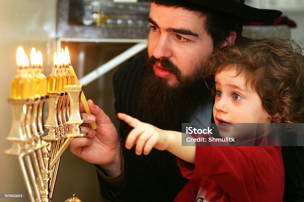 Child watching Father Lighting the Menorah Boy watching his father lighting Menorah on last day of Chanukah. More Chanukah photos: Hanukkah Stock Photo