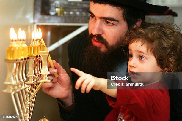 Child Watching Father Lighting The Menorah Stock Photo - Download Image Now - Hanukkah, Family, Judaism