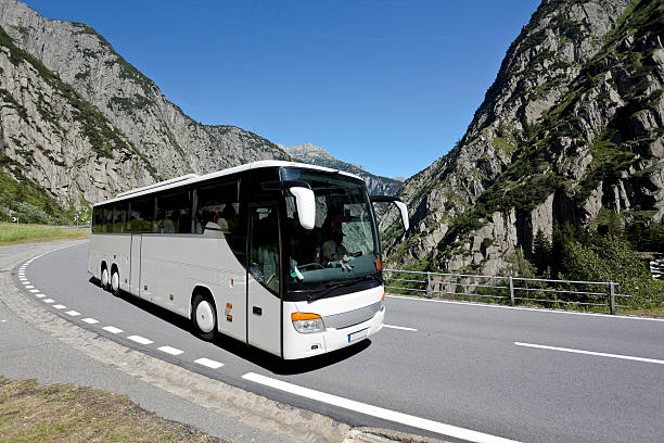 Blue sky over white bus crossing the alpes  coach bus photos stock pictures, royalty-free photos & images