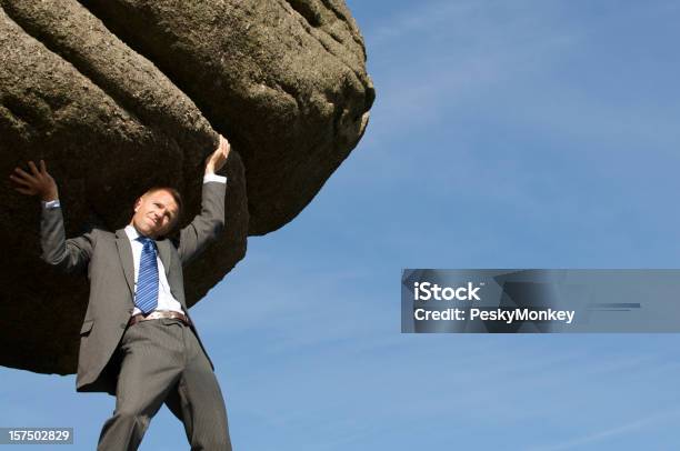 Empresário Segurando Enormes Dificuldades Forte Rock Boulder No Céu - Fotografias de stock e mais imagens de Empurrar - Atividade Física