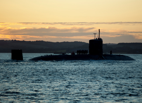 Naval submarine on open sea surface with cloudy sky