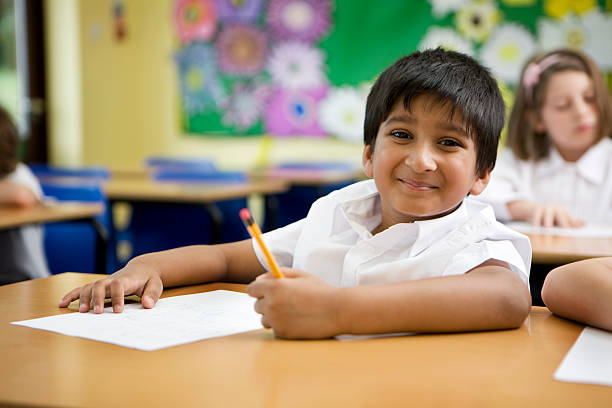 primary school: Indian schoolboy happy and carefree in his classroom stock photo