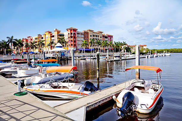 Bayfront Dock and Boats overlooking Naples Bay area with condominiums and shops in background. collier county stock pictures, royalty-free photos & images