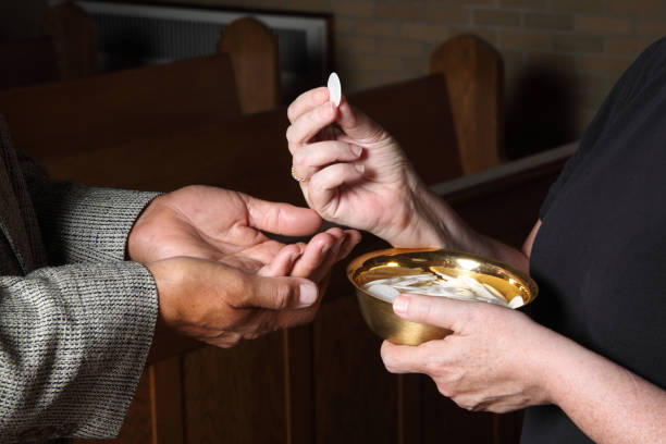Close up of hands giving Communion Woman's hands putting a communion wafer into a man's hands church ladies stock pictures, royalty-free photos & images