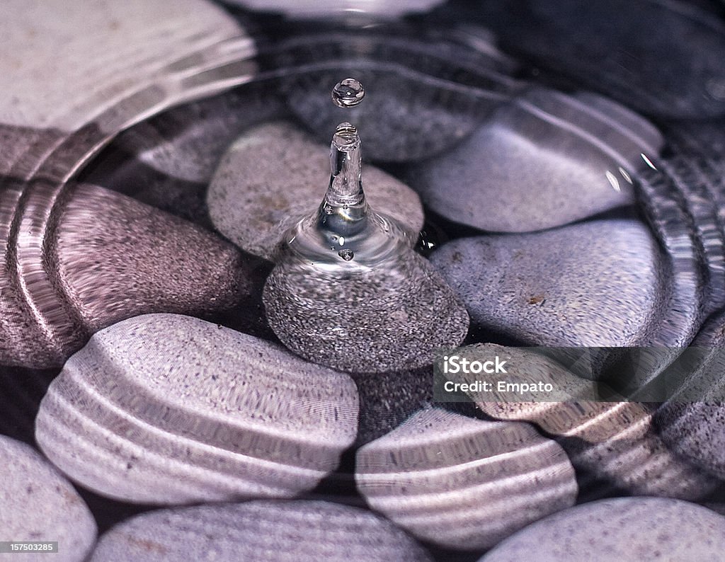 Water droplet over pebbles.  Pebble Stock Photo