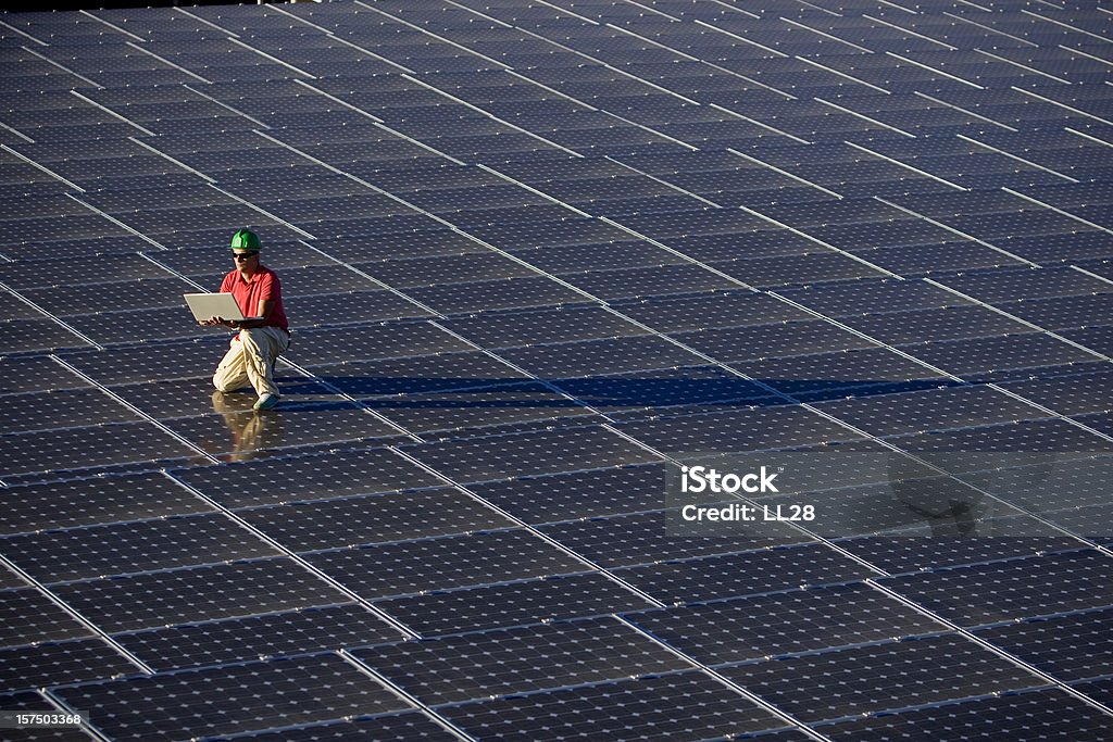 Técnico em uma fazenda photovoltaic - Foto de stock de Painel Solar royalty-free