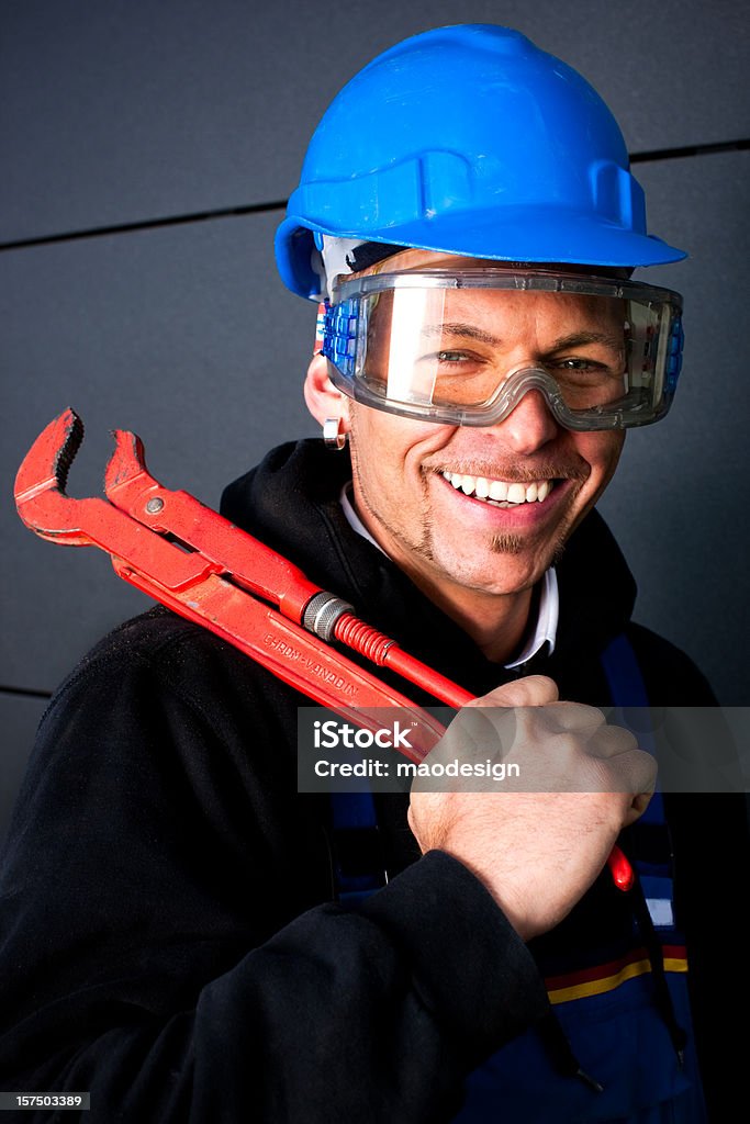 Heureux Travailleur manuel avec Casque de chantier et clé bleu - Photo de Adulte libre de droits