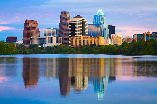 Dramatic sunset with illuminated city office blocks reflected in the golden waters of Lady Bird lake in Austin Texas