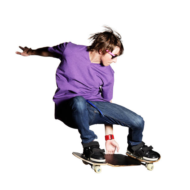 Skateboarder in purple shirt and jeans caught mid-air stock photo