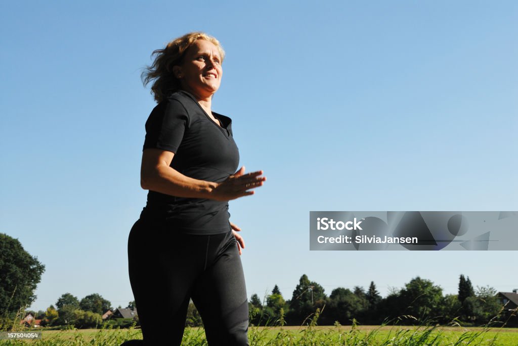 mature woman running mature woman running in summer Jogging Stock Photo