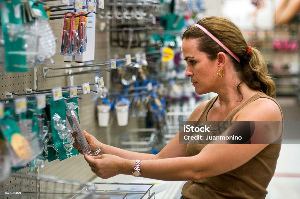 Donna lo Shopping in un negozio di hardware - Foto stock royalty-free di Negozio di ferramenta