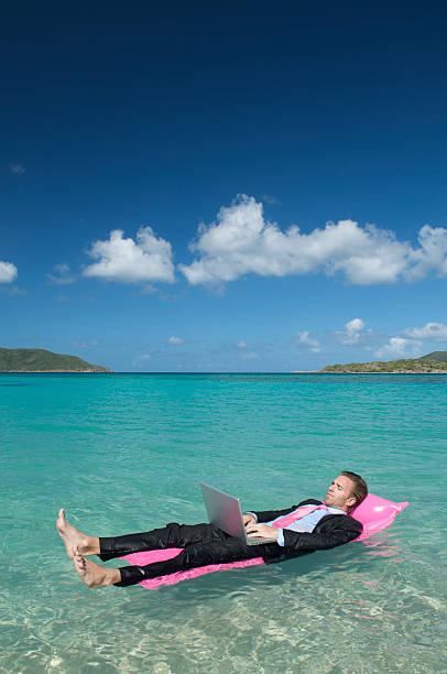 istock Businessman Kicks Back on Lilo w Laptop 157504301