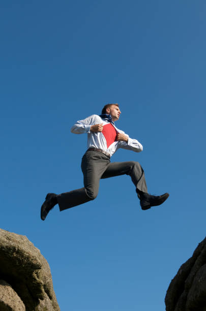 istock Businessman Superhero Jumping into the Sky Between Rocks 157504647