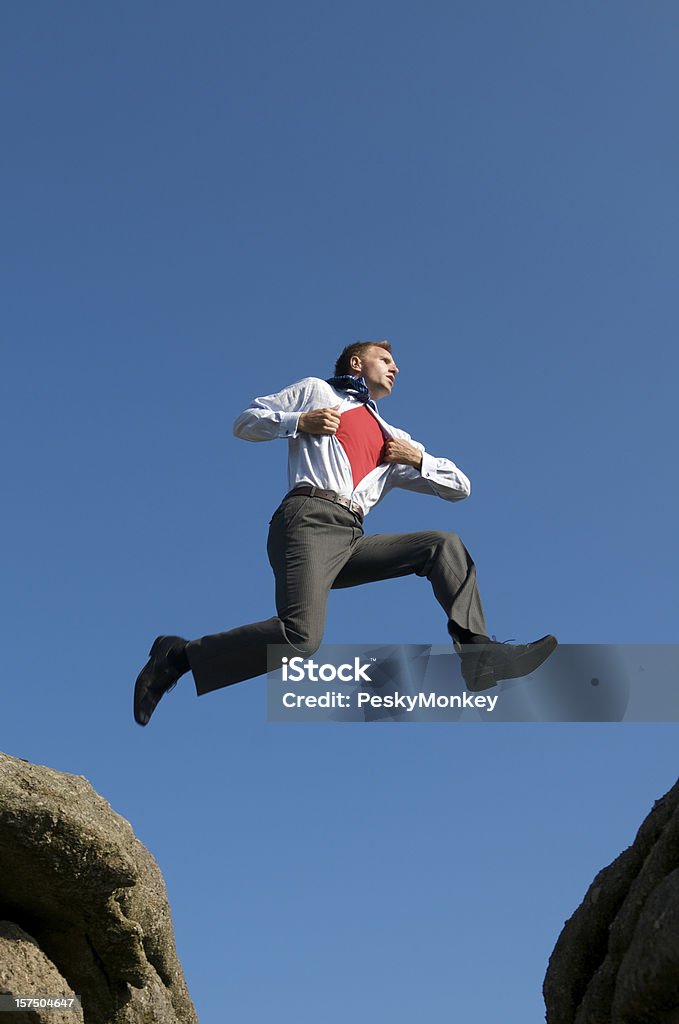 Бизнесмен супергероя прыжки в небе между Скал - Стоковые фото Бизнес роялти-фри