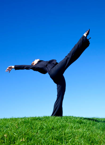 istock businesswoman stretching backwards on green grass 157504827