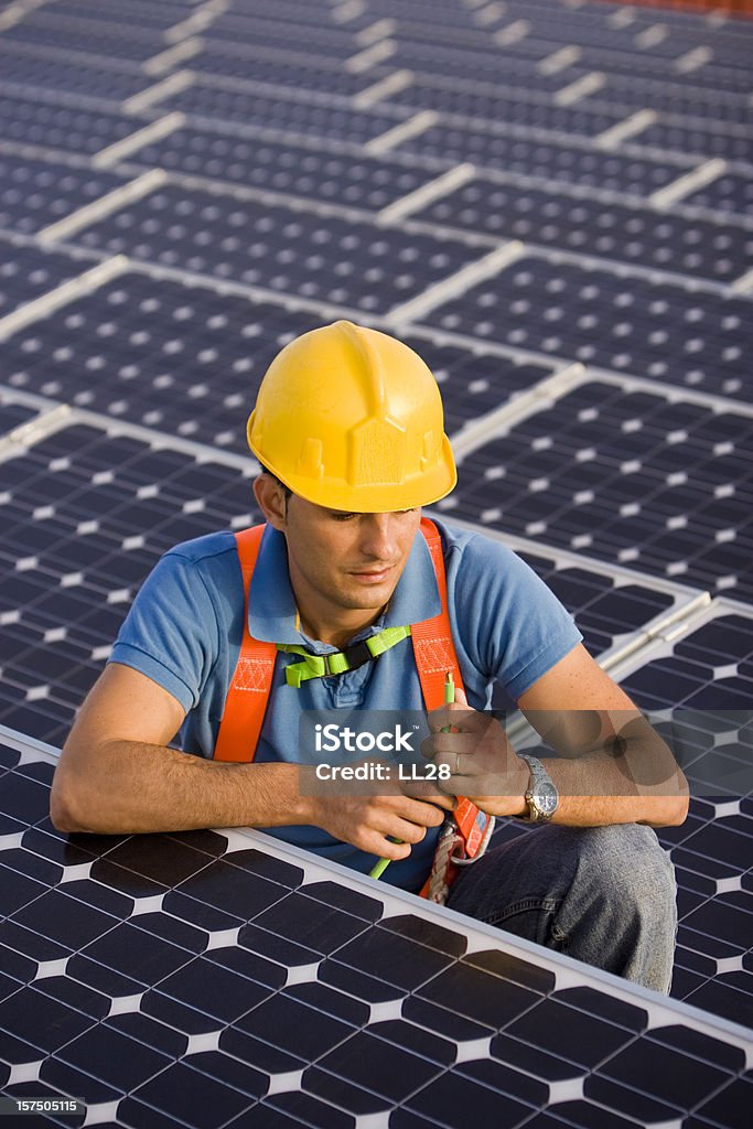 Arbeiter in einem photovoltaic farm - Lizenzfrei Sonnenkollektor Stock-Foto