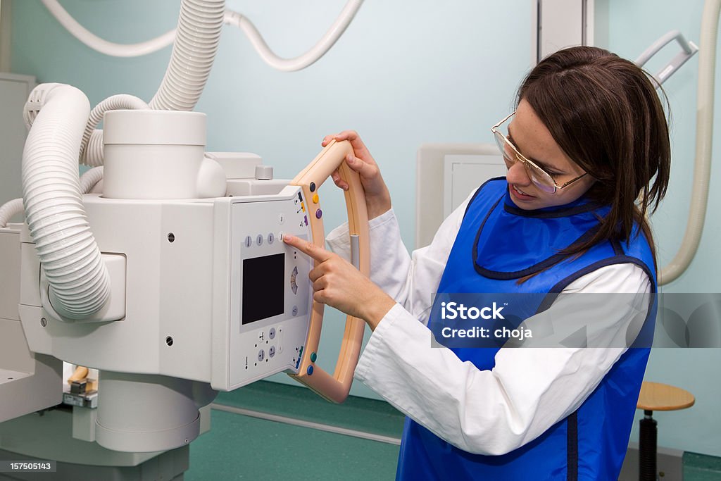 Radiologista jovem trabalhando com moderna máquina de raios X - Foto de stock de Clínica Médica royalty-free