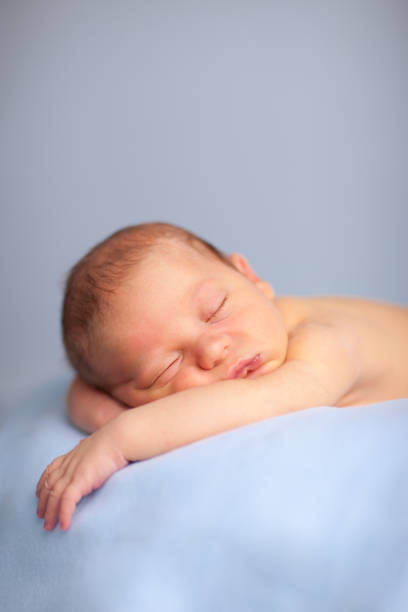 istock Newborn Baby Boy Sleeping Peacefully on Blue Blanket 157505461
