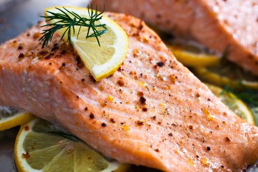 Baked Salmon on a bed of lemon slices.  Selective focus.