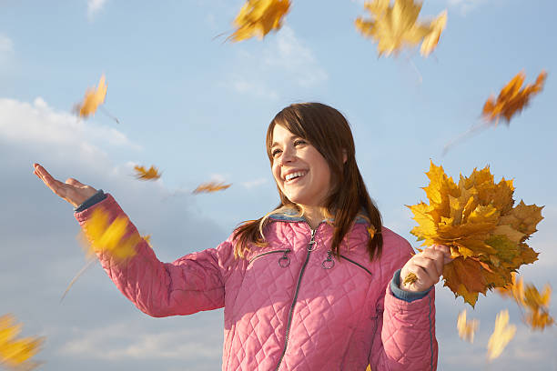 istock Young woman catching yellow maple leaves 157505893