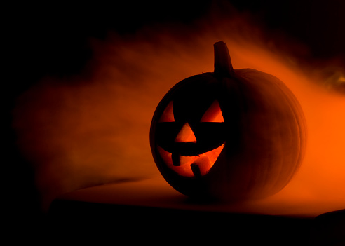 Jack o'Lantern in fire flames. Black background. Horizontal with copy space