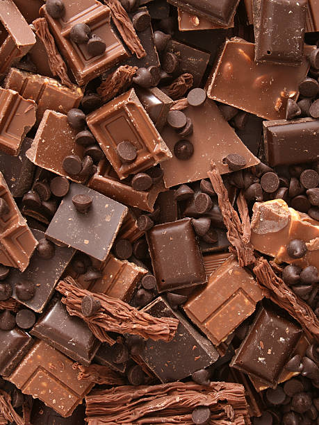 Milk chocolate chunks Top view of lots of milk chocolate pieces chocolate stock pictures, royalty-free photos & images