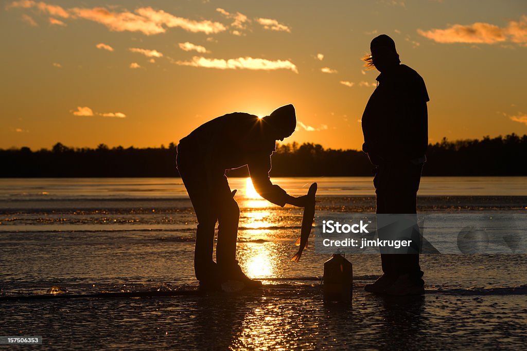Pescador captura de peixes no lago gelado ao pôr do sol. - Royalty-free Pesca no Gelo Foto de stock