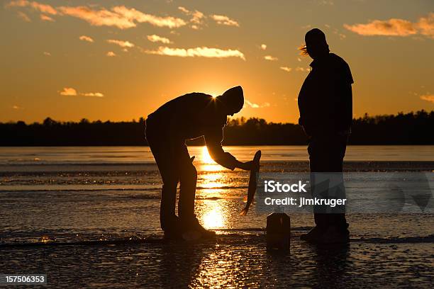 Pescador Captura De Peixes No Lago Gelado Ao Pôr Do Sol - Fotografias de stock e mais imagens de Pesca no Gelo