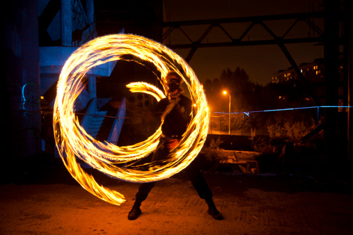Fire performer in motion at night