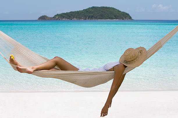 Female relaxing in a hammock at the beach.