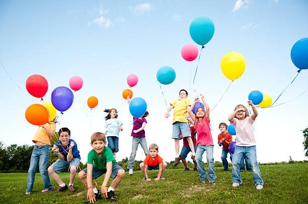 excitación grupo de niños y las niñas de celebrar con globos - child balloon outdoors little boys fotografías e imágenes de stock