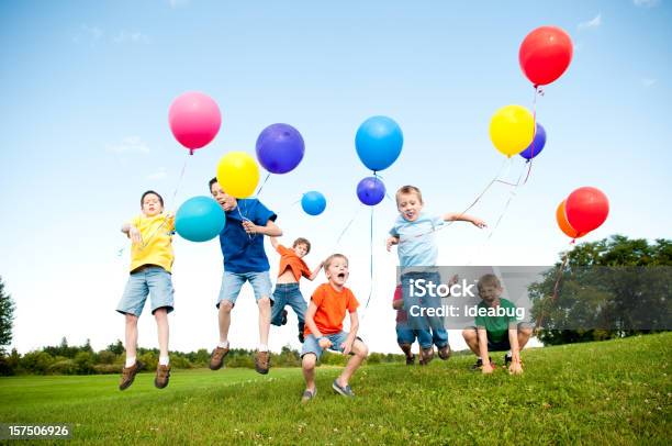 Grupo Entusiasmado Meninos Saltar E Celebrar A Fora - Fotografias de stock e mais imagens de Balão - Enfeite