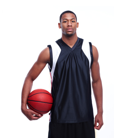 Young basketball player posing at camera on white background.