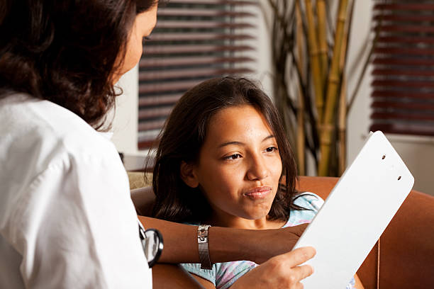 Doctor explaining something to a Latin child stock photo