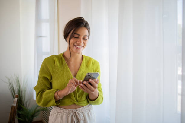 istock Happy young woman using phone 1575073385