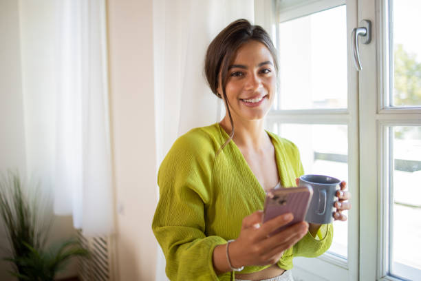 istock Happy young woman using phone 1575073401