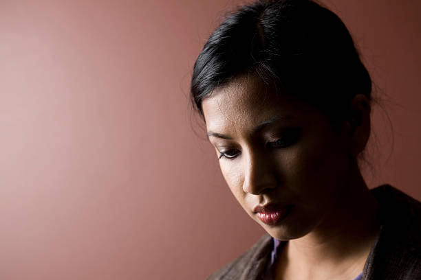 Beautiful young woman studio portrait covered by a veil on a black background.