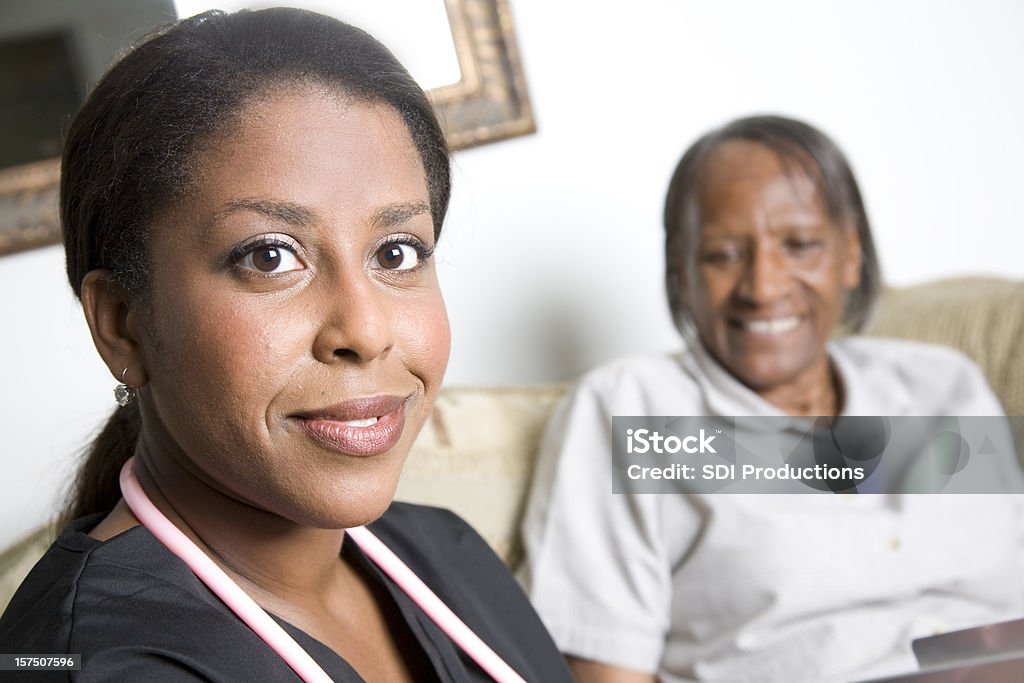 Jovem em casa a enfermeira cuidando de seu paciente idoso - Foto de stock de Adulto royalty-free