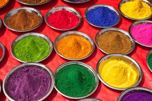 top view of Colorful traditional holi powder in bowls isolated on dark background.Space for text . happy holi.Concept Indian color festival called Holi