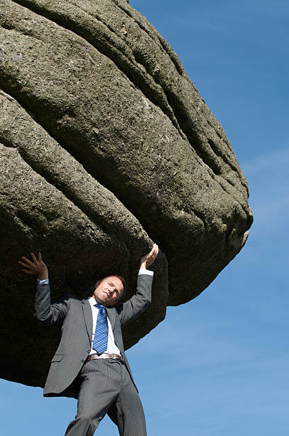 istock Businessman Struggling Outdoors Lifting Massive Heavy Boulder 157507784