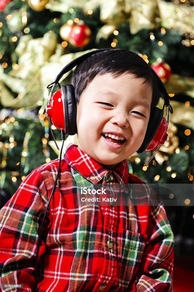 Niño atractivo mientras escucha música navideña - Foto de stock de Navidad libre de derechos