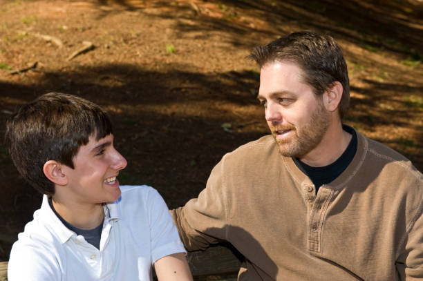 istock Father and Son Talking on a Bench in Park 157507872