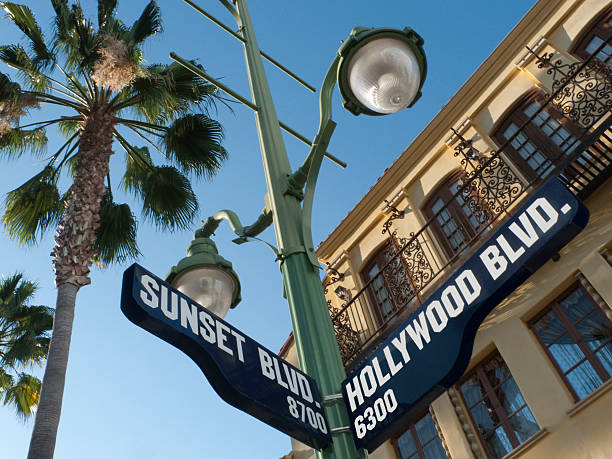 sonnenuntergang und hollywood boulevard street sign - hollywood los angeles stock-fotos und bilder