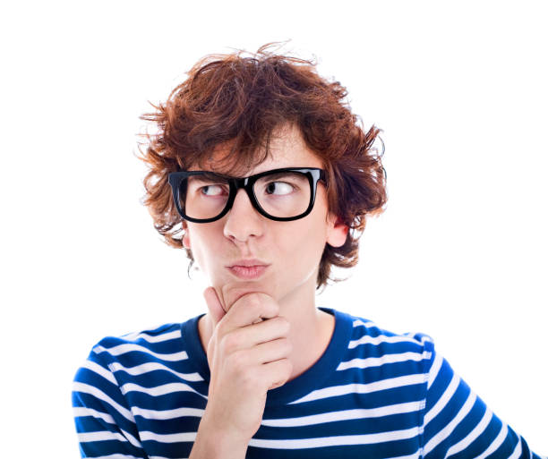 Nerdy Teenager Thinking, Studio Portrait Portrait of a late teen boy wearing black thick rimmed glasses, looking away and thinking.   one teenage boy only stock pictures, royalty-free photos & images