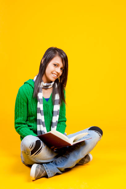 istock Cheerful hispanic student sitting on floor studying book. 157508494