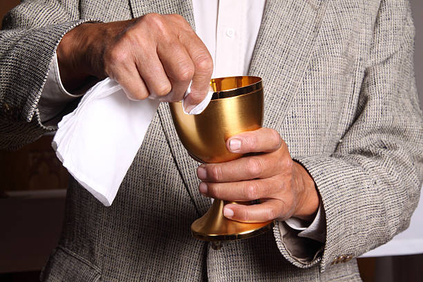 The hands of a Catholic priest administering Holy Communion