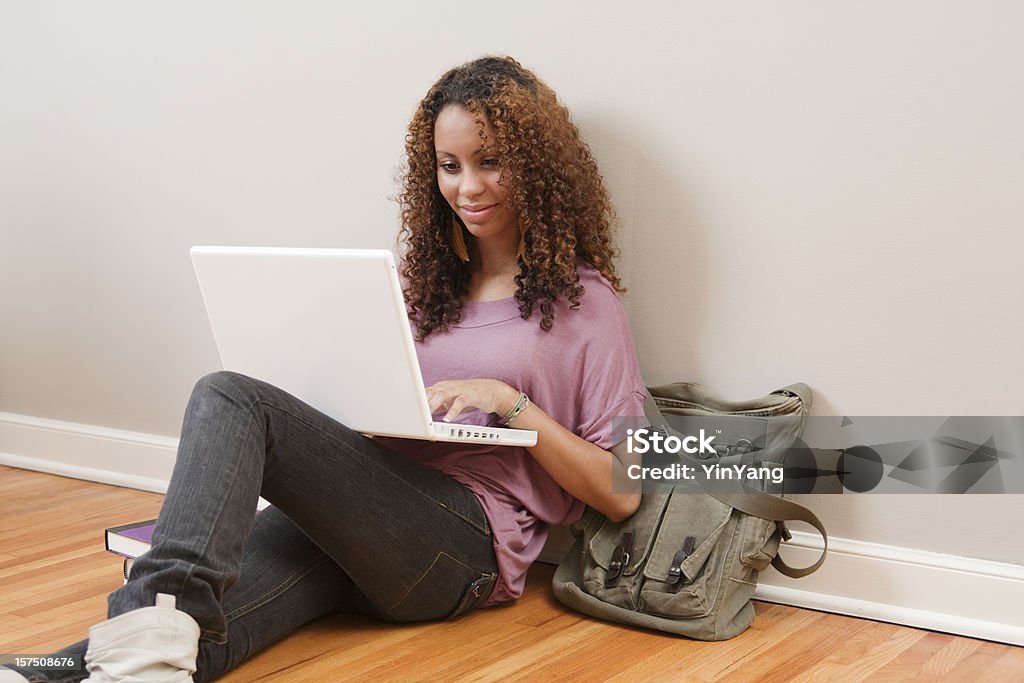 Jovem adolescente negra feminino estudante usando o Laptop no andar Hz - Foto de stock de 18-19 Anos royalty-free