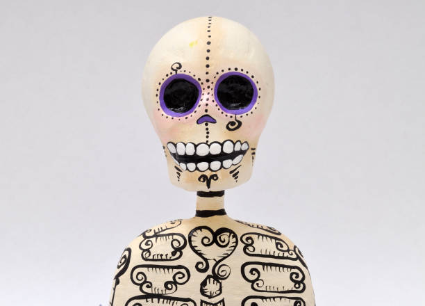 A striking close-up of a vibrant skull-shaped sculpture in orange and yellow tones with detailed patterns. The soft bokeh background highlights its unique artistic design, blending elements of modern pop art and abstract creativity for a bold visual impact.
