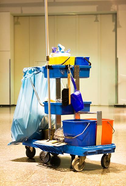 shot of a service cart with many cleaning products, bags, buckets, spray bottles standing in a hotel in the entrance hall. The room is empty and brightly lit. The cleaning staff is not in the picture. A little break, then goes on .. there is much to do. The soil needs to be wiped before new guests arrive at a public event.