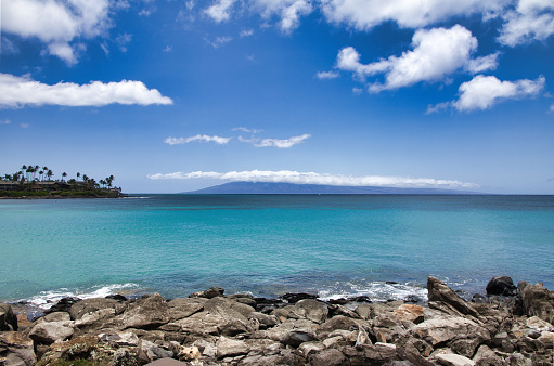 View of beautiful ocean and distant lanai from the shore of Napili Bay.